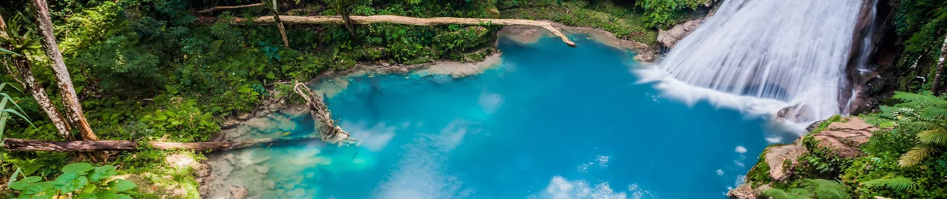Přírodní jezírko Blue Hole s vodopádem Přírodní jezírko Blue Hole s vodopádem